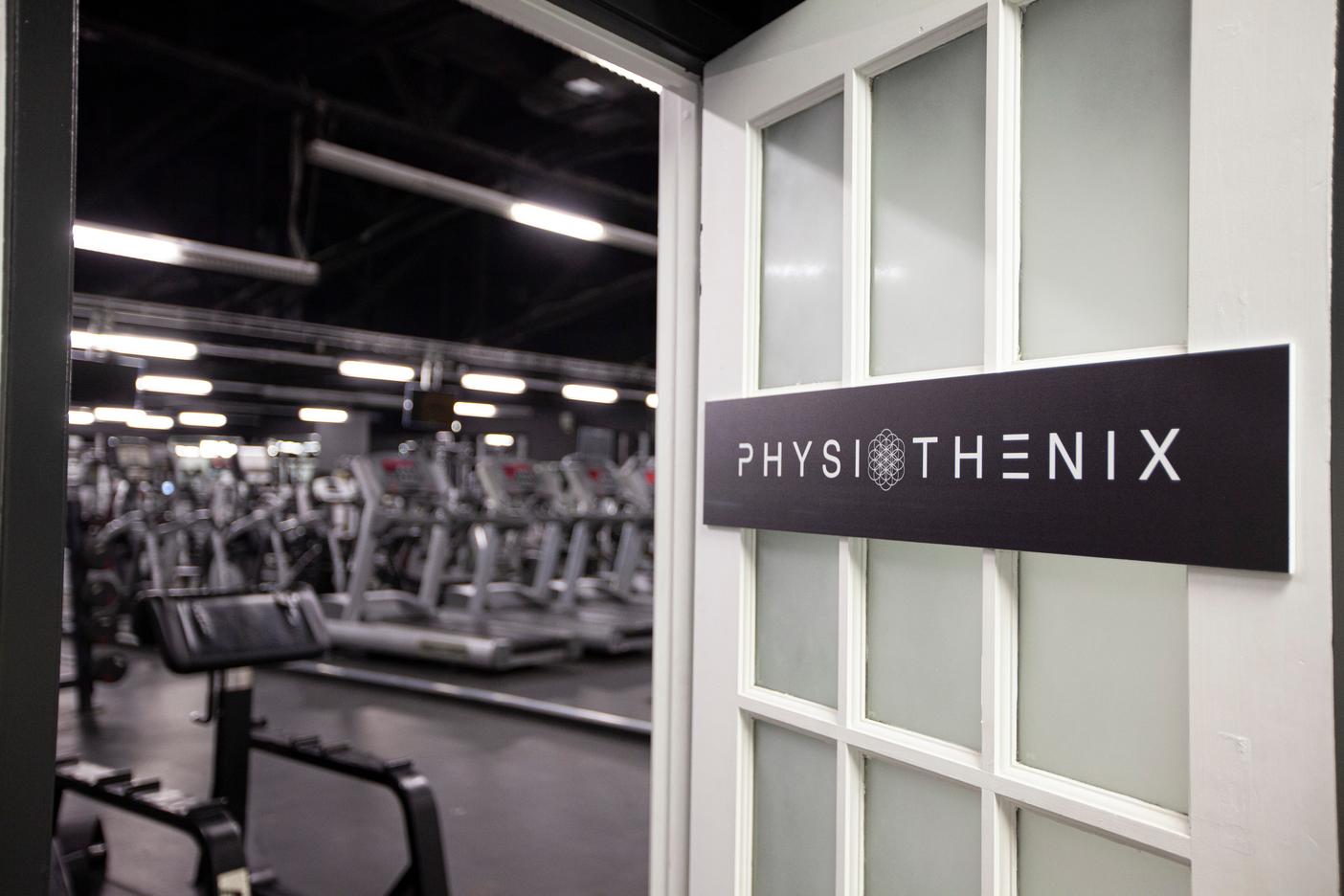 physiothenix sign on open door, revealing gym outside